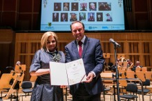 Fotografia kobiety i mężczyzna trzymają teczkę z nazwiskiem laureatki - zdobywczynią Pomorskiej Nagrody Artystycznej