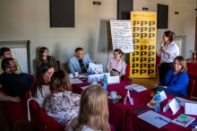 zdjęcie ludzi wewnątrz, rozmawiają przy stole, szkolenie, warsztaty. spotkanie