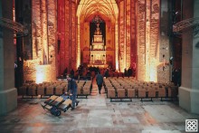 Widok na centrum św. jana - pracownicy roznoszą krzesła po nawie głównej