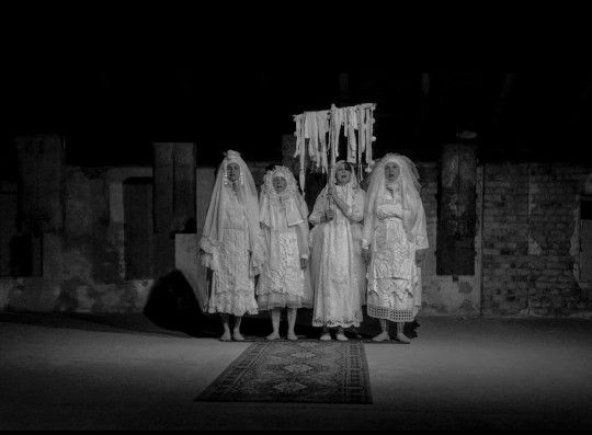 Cztery kobiety w białych strojach z welonami.