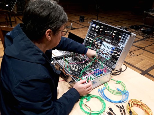 muzyk grający na elektronicznym instrumencie przypominającym walizkę