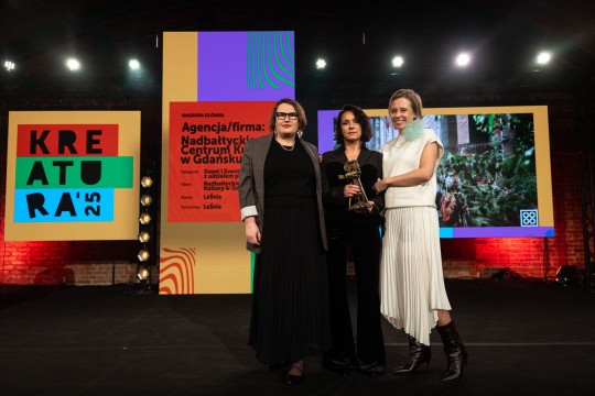 zdjęcie 3 kobiet na scenie trzymają statuetkę, w tle napis kreatura