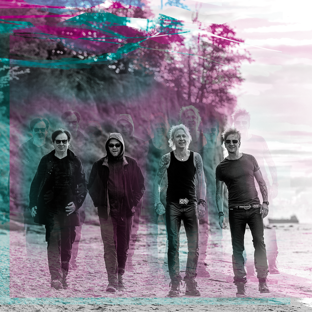 Czterech muzyków spaceruje po plaży, w tle klif
