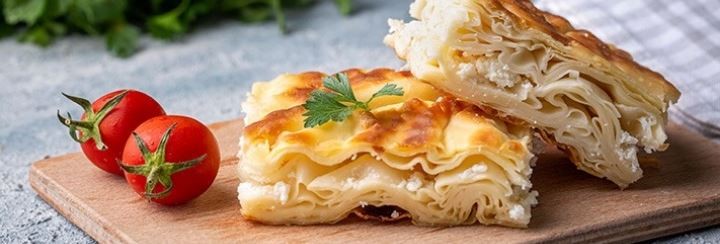 Dwa kawałki tureckich wypieków i dwa małe pomoidory. 