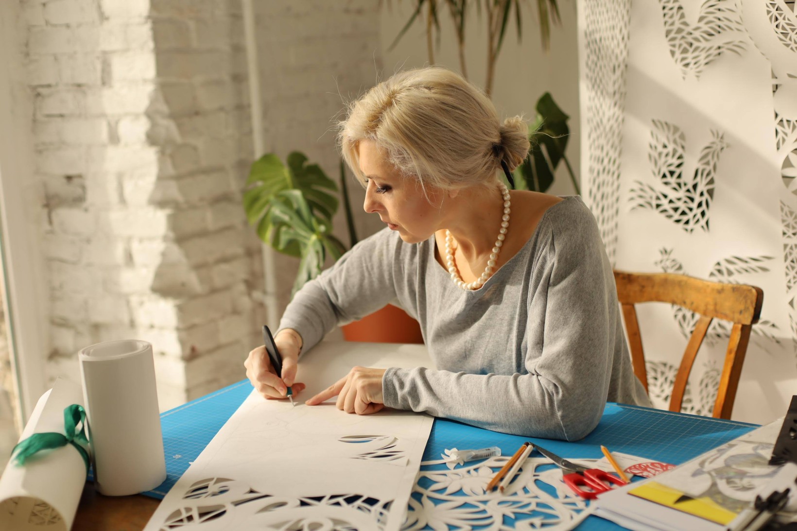 Zdjęcie na którym artystka (Daria Alyoshkina) tworzy wycinankę.