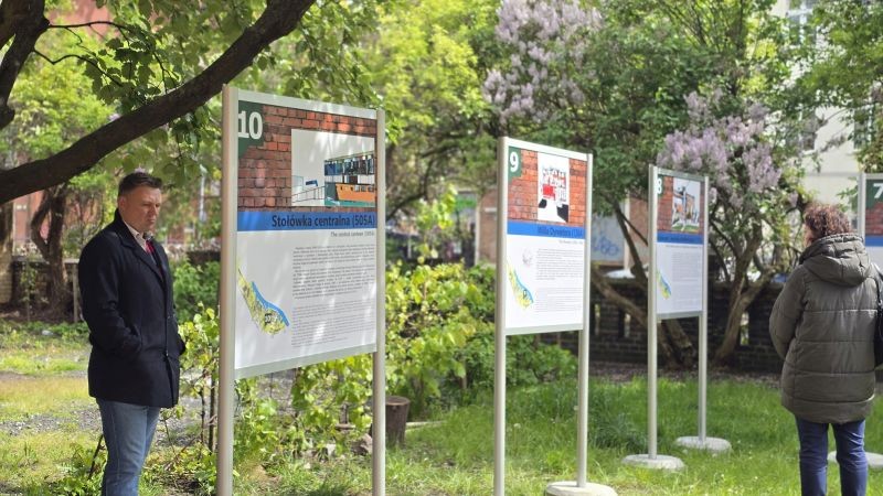 zdjęcie na zewnątrz, tablice na terenie zielonym, dwie osoby przyglądają się