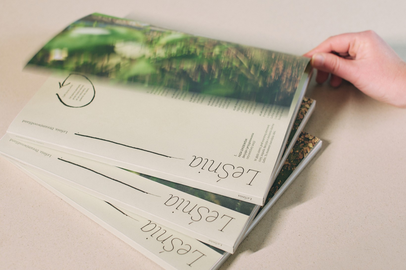 zdjęcie trzech książek, dłoń chwyta z okładkę