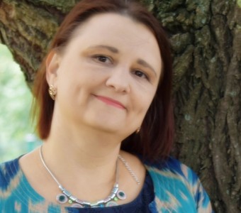 W centrum zdjęcia Oksana Szatogo, oparta o drzewo