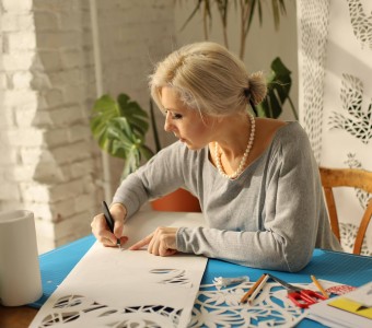 Zdjęcie na którym artystka (Daria Alyoshkina) tworzy wycinankę.