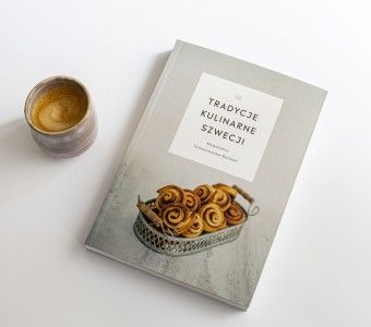zdjęcie kubka z kawą i książki pt. "Tradycje kulinarne Szwecji"