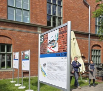 zdjęcie na zewnątrz, tablice z planszami na tle NCK - Ratusza Staromiejskiego